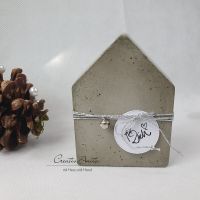 Handgemachtes Haus aus Beton, dekoriert mit Silberkordel